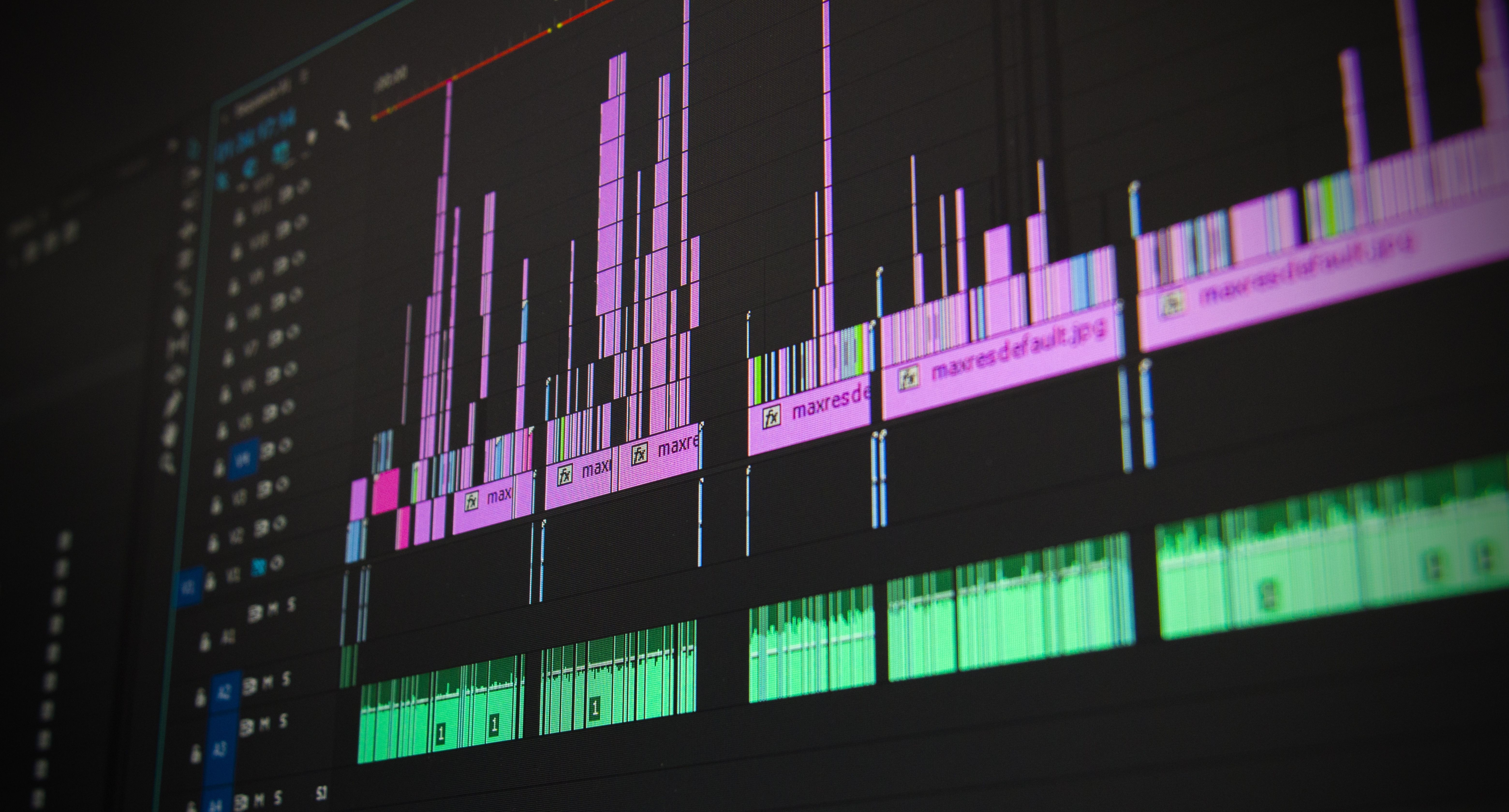 up close image of a computer screen with video editing app opened and shows audio waves